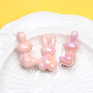 Luminous bunny resin beads with pearlescent finish displayed on a white plate