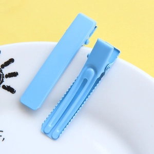 Detailed close-up of light blue duckbill hair clips with non-slip serrated edge design