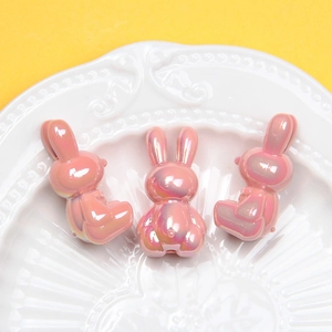 Detail of pink pearlescent rabbit beads with iridescent finish for DIY crafts