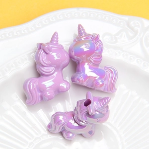 Gros plan de trois perles licorne en résine irisée violette pour bijoux DIY et breloques