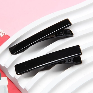 Detail of 4.8cm glossy black duckbill clips with smooth electroplated finish on display