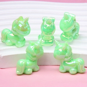 Gros plan de cinq perles licornes lumineuses vert aurore pour bijoux DIY
