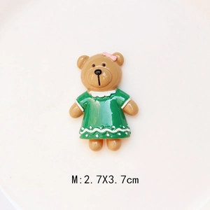 Detail of a brown resin bear with a green dress and bow for DIY crafts, size 2.7x3.7cm