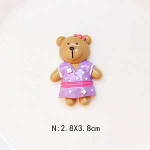 Detailed macro view of a 2.8x3.8cm resin bear accessory with a bow and floral dress