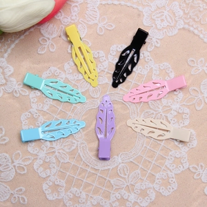Detailed macro of seven hollow leaf-shaped hair clips in various pastel colors