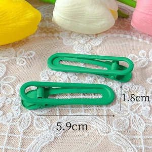 Pair of matte grass green 6cm hair clips shown on lace with size dimensions
