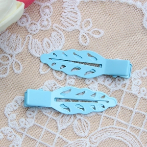 Set of two sky blue leaf-shaped hollow metal hair clips on a lace background