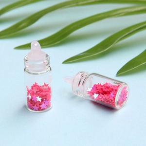 Dettaglio mini bottiglia di vetro con paillettes a stella rosa e anello superiore