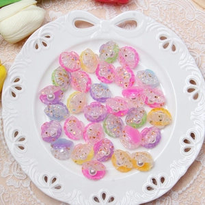 Macro view of shell-shaped resin charms with faux pearls and gold star glitter