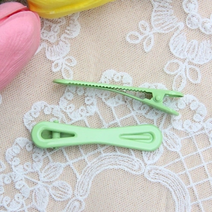 Macaron lichtgroene 2-delige haarclipset op een delicate witte kanten achtergrond