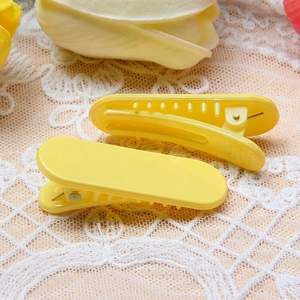 Barrettes à cheveux jaune macaron avec ressorts métalliques sur fond de dentelle