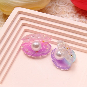 Macro detail of gradient resin shell with faux pearl and glitter for DIY jewelry
