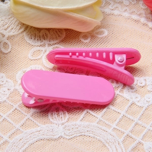 Gros plan de pinces à cheveux rose macaron avec dents antidérapantes sur dentelle