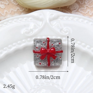 Macro d'une breloque boîte cadeau à paillettes de 2cm avec nœud rouge pour loisirs créatifs