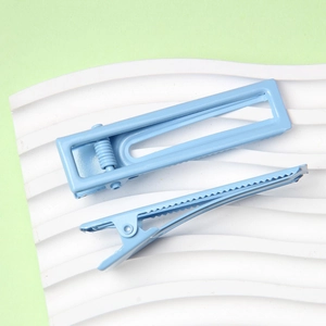 Détail de barrettes à cheveux en métal bleu clair mat avec motif carré évidé et bec