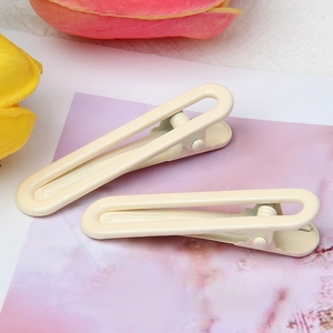 Detail of cream-white matte metal U-shaped hair clips with hollow design and anti-slip teeth