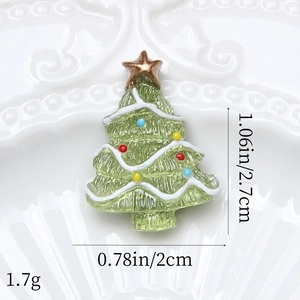 Dettaglio di un ciondolo a forma di albero di Natale in resina verde con stella dorata