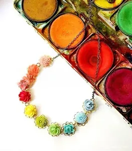 Detail of colorful resin floral necklace with gold-hued settings and vintage metal chain