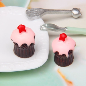 Miniature star cupcakes with pink cream and chocolate cups on a white plate set