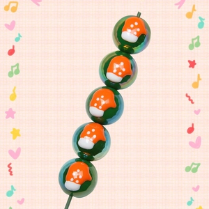 Detail of green acrylic Christmas beads with orange mushroom patterns for DIY jewelry