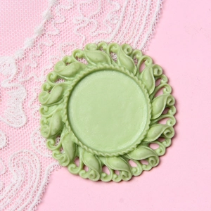Detail of 2.5cm pale green resin round frame base with vintage embossed leaf pattern