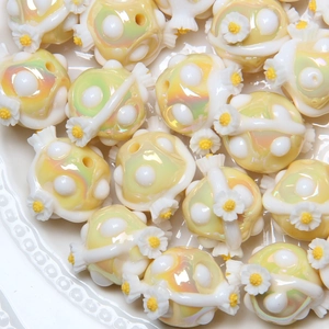 Detail of hand-painted aurora yellow beads with daisy and ribbon for DIY jewelry