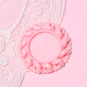 Macro shot of pink silicone jewelry mold featuring intricate vintage floral relief patterns
