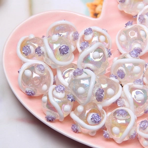 DIY colorful iridescent glass beads with white swirls and purple rose detail in a heart dish