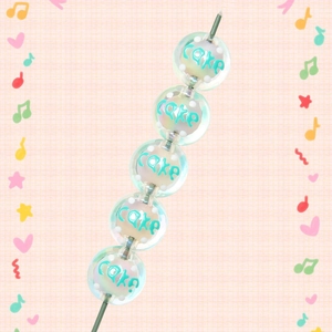 Detailed macro of acrylic Christmas beads with blue Cake lettering and white dots