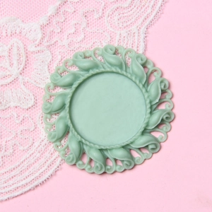 Detail of 2.5cm mint green round cameo base with vintage embossed resin floral patterns