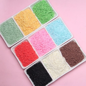 Macro view of colorful polymer clay crumbs in a white tray for DIY crafts