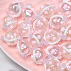 Close-up of pink iridescent hand-painted beads with white swirls and pearlescent finish