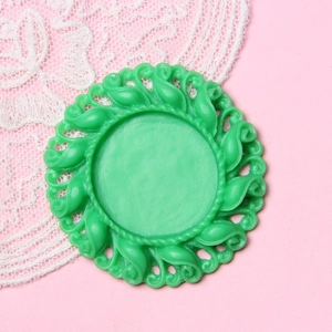 Macro view of a 2.5cm green vintage style round DIY jewelry base with floral relief