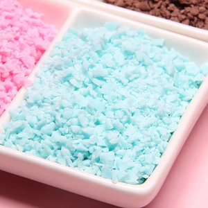 Close-up of pastel polymer clay flakes in a white ceramic tray for DIY craft projects