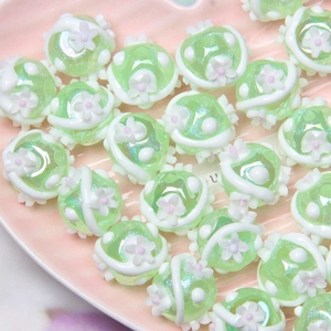 Detailed macro view of mint green floral glass beads for DIY jewelry making