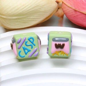 Close-up of green cube silicone beads for DIY jewelry with colorful relief patterns