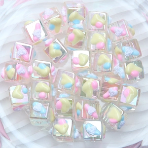 Macro shot of iridescent square DIY beads with colorful resin hearts and roses