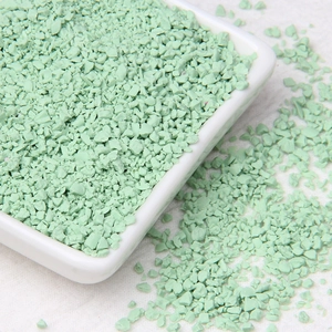 Detail view of light green irregular stone granules in a minimalist white square ceramic dish