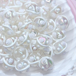 Macro view of hand-painted white iridescent 3D floral DIY beads for jewelry making