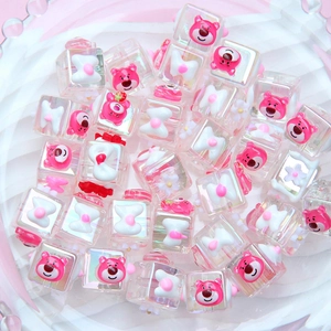 Detail view of Lotso strawberry bear and bow motifs on aurora iridescent acrylic cubes