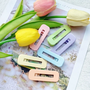 Close-up of six macaron-colored matte rectangular hair clips with floral decor
