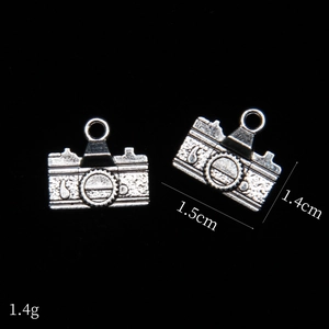 Macro detail of vintage camera alloy pendants in antique silver finish for DIY jewelry
