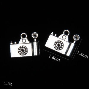 Detailed macro view of vintage silver camera charms with 1.6cm x 1.4cm dimensions
