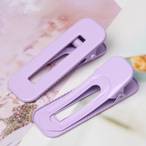Macro detail of matte lavender rectangular hollow metal hair clips with duckbill base