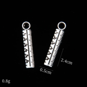 Macro view of ruler-shaped antique silver alloy pendant with dimensions 2.4cm by 0.5cm