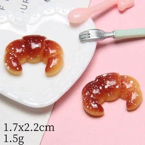 Miniature resin cream croissant with sugar frost detail in a heart-shaped dish
