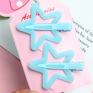 Detail of two matte light blue star hair clips displayed on a strawberry pattern card