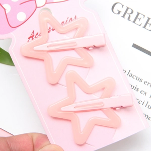 Close-up of pink star-shaped hair clips in hollow design on product display card
