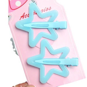 Pair of light blue star-shaped hair clips on a pink Accessories display card