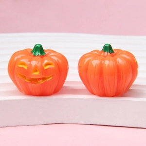 Detailopname van feloranje hars pompoen decoraties op een roze achtergrond